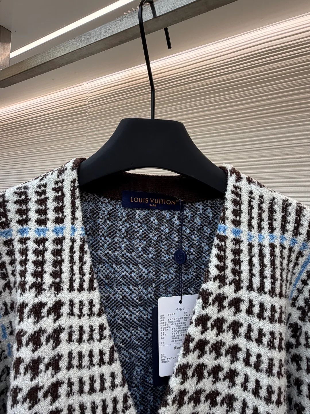 LOUIS VUITTON letter intarsia houndstooth knitted jacquard cardigan ●Original version: purchased and developed by 14743 ●Item number: 1681873-C00 ●Fabric: wool blended fabric ●Technology: jacquard knitting ●Color: black, white and blue ●Version: fitted version ●Weight: about 695 grams ●Size: S-M-L-XL ●Description: The main pattern of this cardigan is woven with full-width jacquard technology, using 69% sheep wool blended with 31% nylon yarn to interweave the houndstooth pattern with light blue line texture. At the same time, the brand logo elements are integrated into the body through intarsia technology, and the edges of the pattern are connected delicately and seamlessly. The collar, cuffs and hem are made of 100% sheep wool ribbed fabric, and are edged with double-needle seaming technology, which has both elasticity and shaping effect. The front placket is equipped with natural-textured buttons, and the side seam pockets use invisible stitching technology to blend naturally with the jacquard texture of the body. The overall shape is shaped through three-dimensional tailoring, and the shoulders are stitched with seamless stitching to ensure fit and comfort. The entire piece is finished with handcrafted details in an Italian workshop, showing the craftsmanship precision of high-quality knitted items. The overall wiring is straight and delicate, the fabric is comfortable and soft, and the color is consistent without color difference. It can be matched with the same style to create a fashionable look and control various occasions. Customized accessories, complete with three standards, same style for men and women!